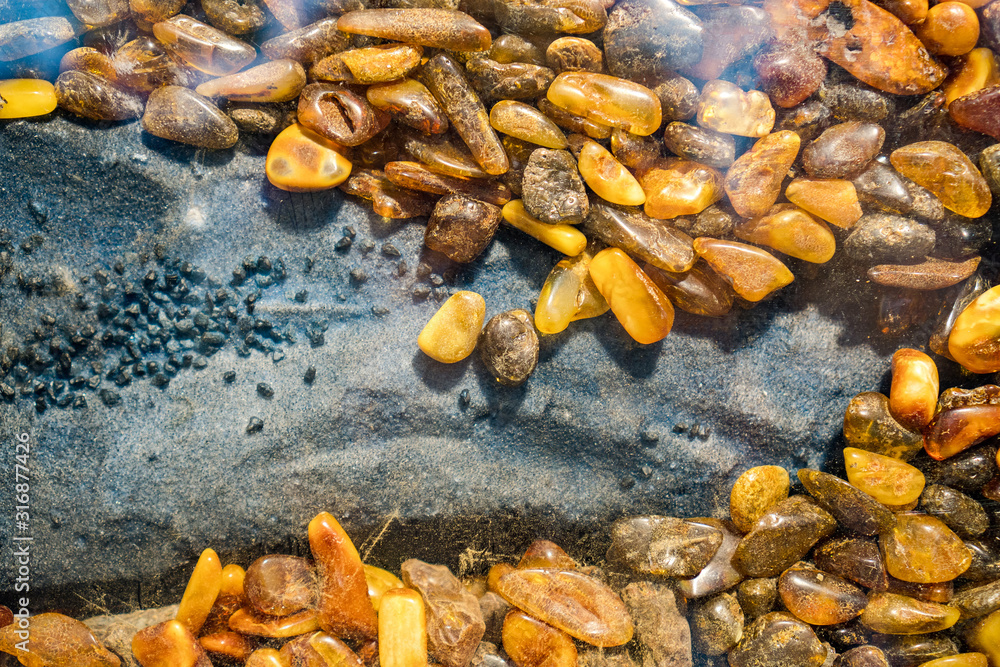 Amber grains with backlight illumination as texture or background. heap of amber stones backlightet glowing. Small raw amber. amber stones rectangular lie on a flat surface Amber grains with backlight illumination as texture or background. heap of amber stones backlightet glowing. Small raw amber. amber stones rectangular lie on a flat surface