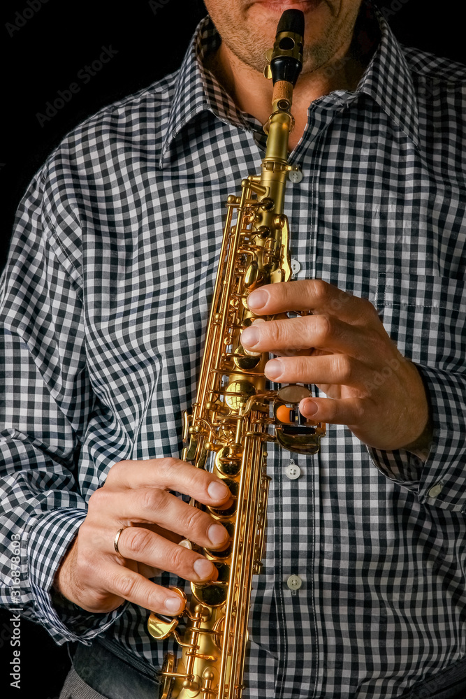 Fototapeta premium soprano saxophone in hands on a black background