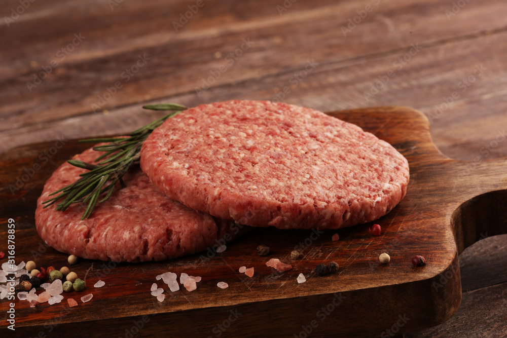 raw patty for angus burger on wooden cutting board. patty for burger raw patty for angus burger on wooden cutting board. patty for burger