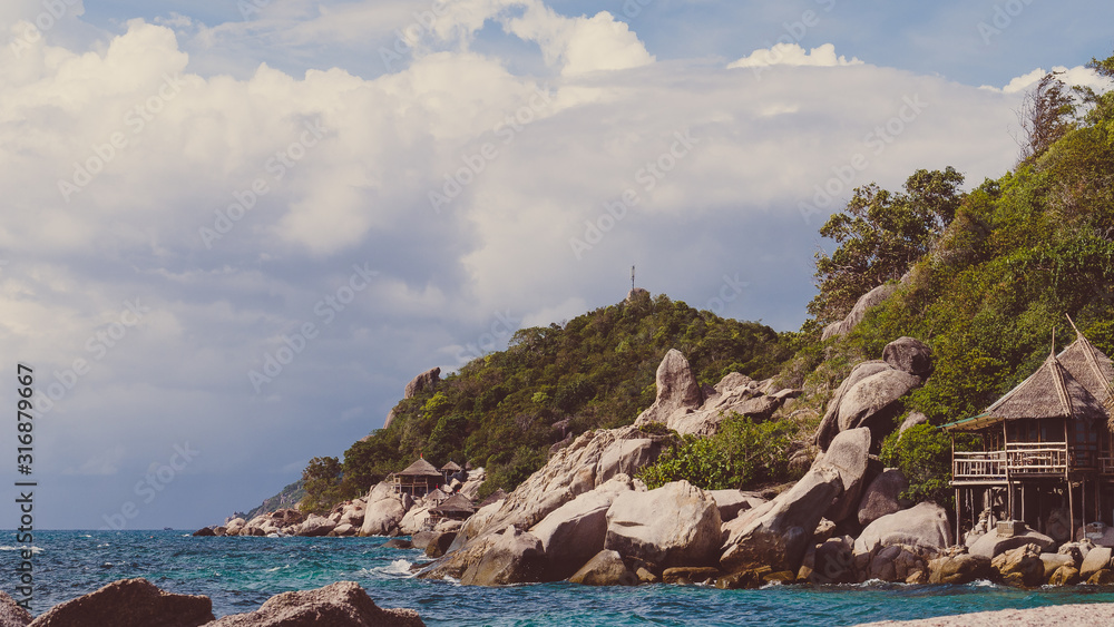 Costline of Koh Tao Islands in Thailand. Granite Rocks and blue clear water hitting Rocks