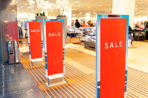 Картината върху платно Red bright sale banner on anti-thieft gate sensor at retail shopping mall entrance