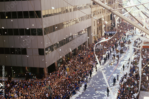 City street corner with parade and crowd photo