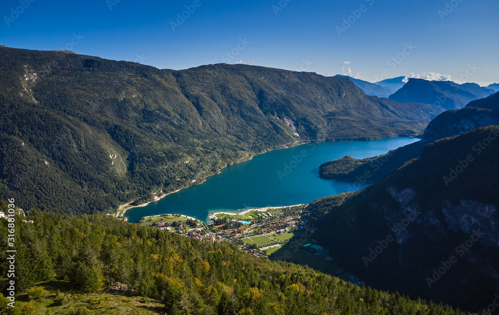 Aerial view over the beautiful Molveno town and Molveno lake, an alpine lake in Trentino, Italy
