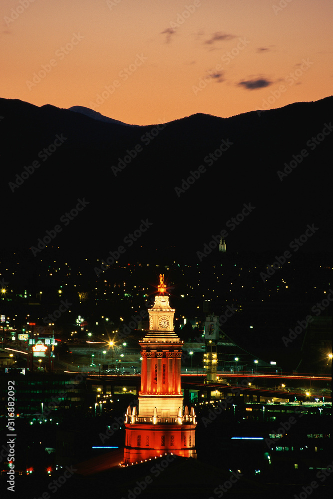 Fototapeta premium Lit clock tower against Denver and peaks beyond