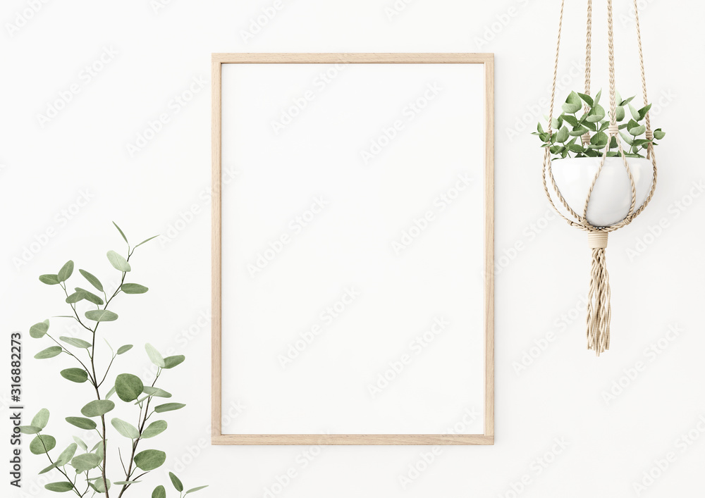 Fototapeta Makieta plakatu wewnętrznego z pionową drewnianą ramą na pustej białej ścianie ozdobiona gałęzią rośliny i wiszącą doniczką z makramy. Format A4, A3. Renderowanie 3D, ilustracja.