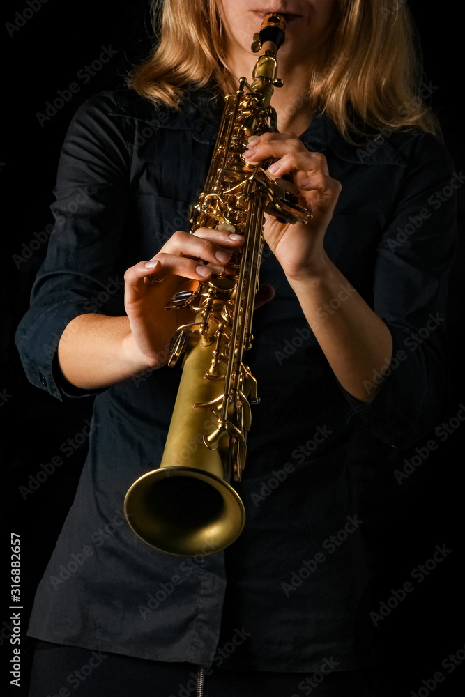 Obraz premium soprano saxophone in hands on a black background