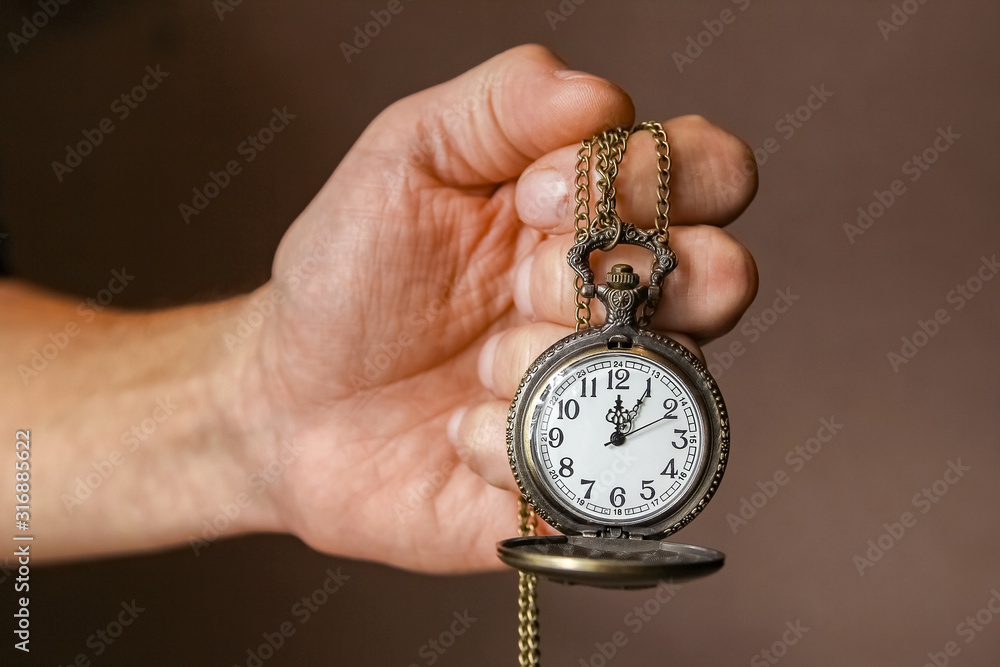 a pocket watch in the hands of a man