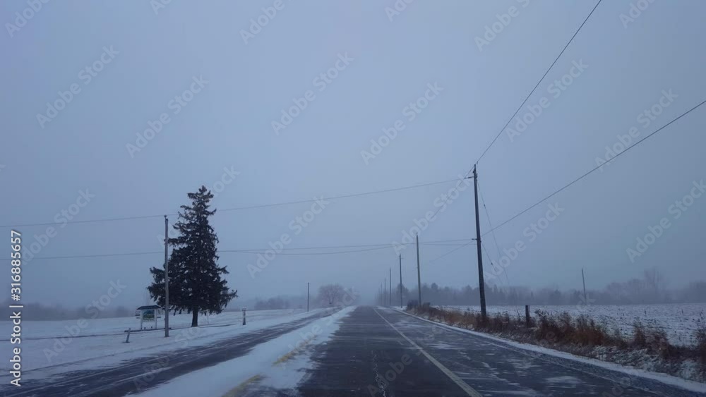 Driving Winter Snow Storm on Rural Road in Day. Driver Point of View POV Snowing Blizzard Snowfall on Countryside Road. Driving Winter Snow Storm on Rural Road in Day. Driver Point of View POV Snowing Blizzard Snowfall on Countryside Road.
