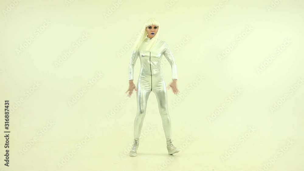 Robot girl is dancing. Pretty sexy blonde robot or alien in silver overalls is dancing. Robot girl is dancing. Pretty sexy blonde robot or alien in silver overalls is dancing.