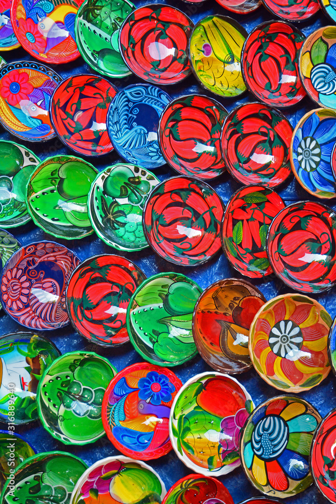 Numerous colorful Mexican plates on display