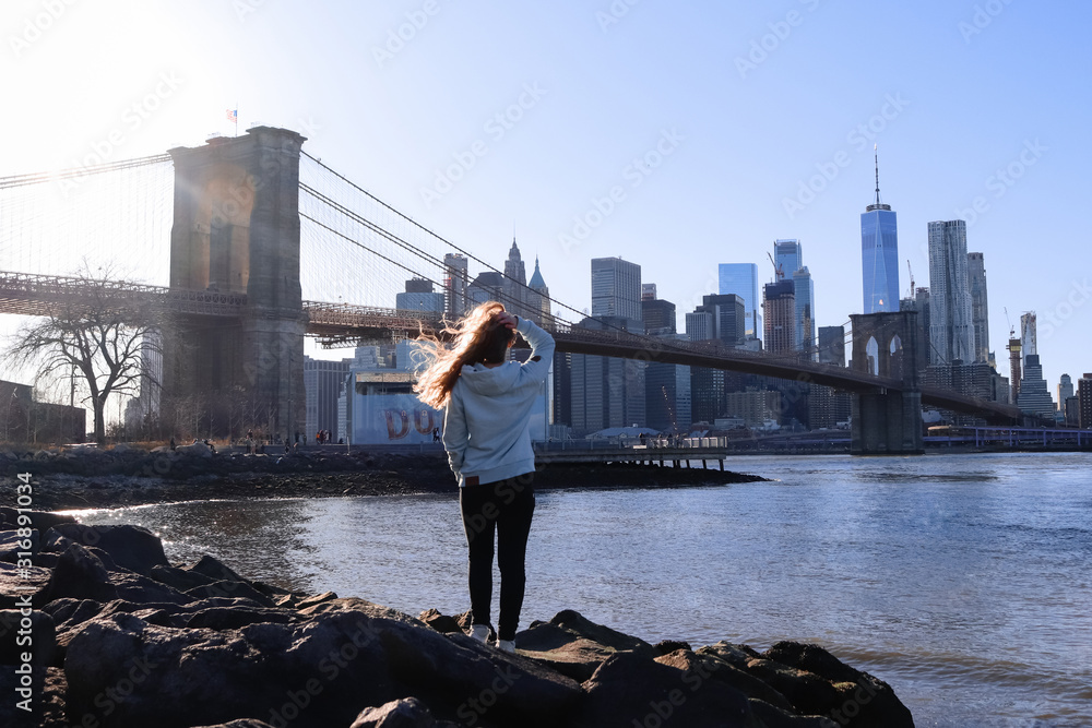 Blonde Frau von hinten vor Brooklyn Bridge in New York