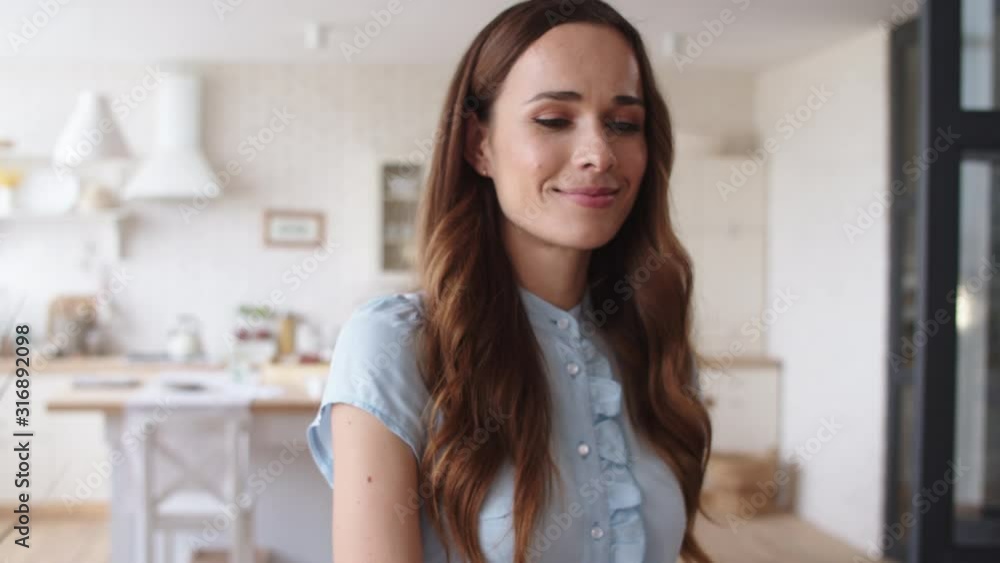 Smiling woman coming up to husband from behind in apartment. Man hugging wife. Smiling woman coming up to husband from behind in apartment. Man hugging wife.