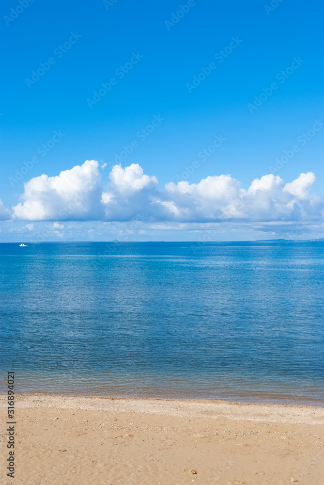 晴れた日の透き通った海に写った雲と空の風景