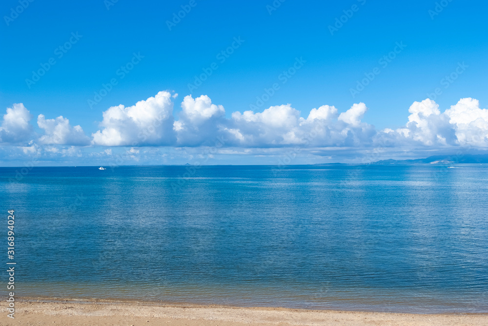 Fototapeta premium 晴れた日の透き通った海に写った雲と空の風景