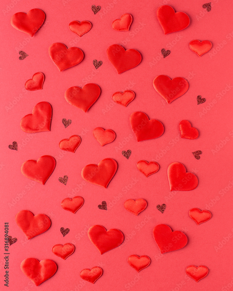 Valentines day composition - decorative hearts on red background. Greeting card. Flat lay, top view.
