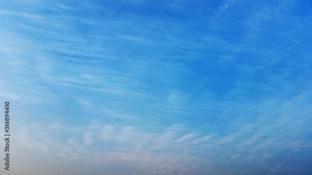 A Blue Sky Abstract. A blue sky with just a wisp of cloud to use being a backing or backdrop royalty free stock photo.