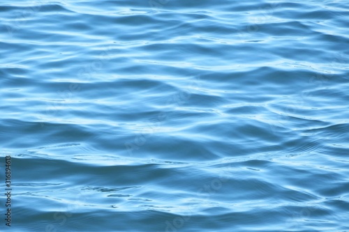 Beautiful light blue glared water surface, natural background 