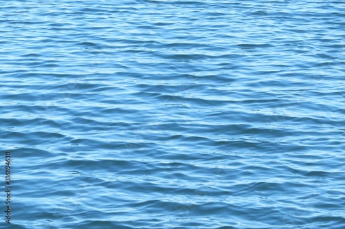 Ripples on light blue water surface in Florida river, natural water background