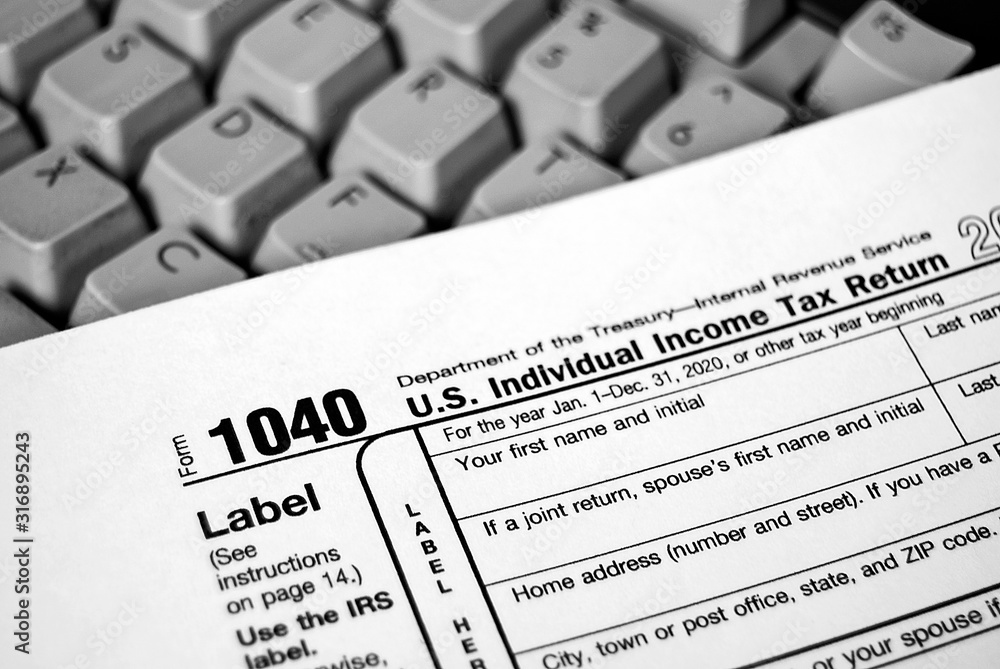 Obraz premium close up of Internal Revenue Service 1040 income tax form on computer keyboard