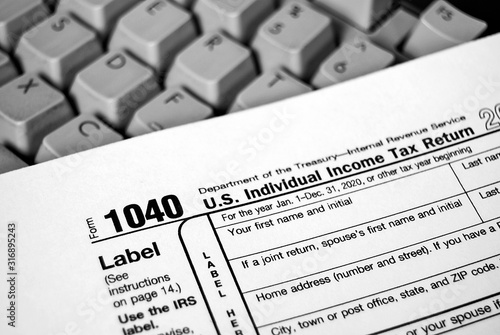 close up of Internal Revenue Service 1040 income tax form on computer keyboard photo