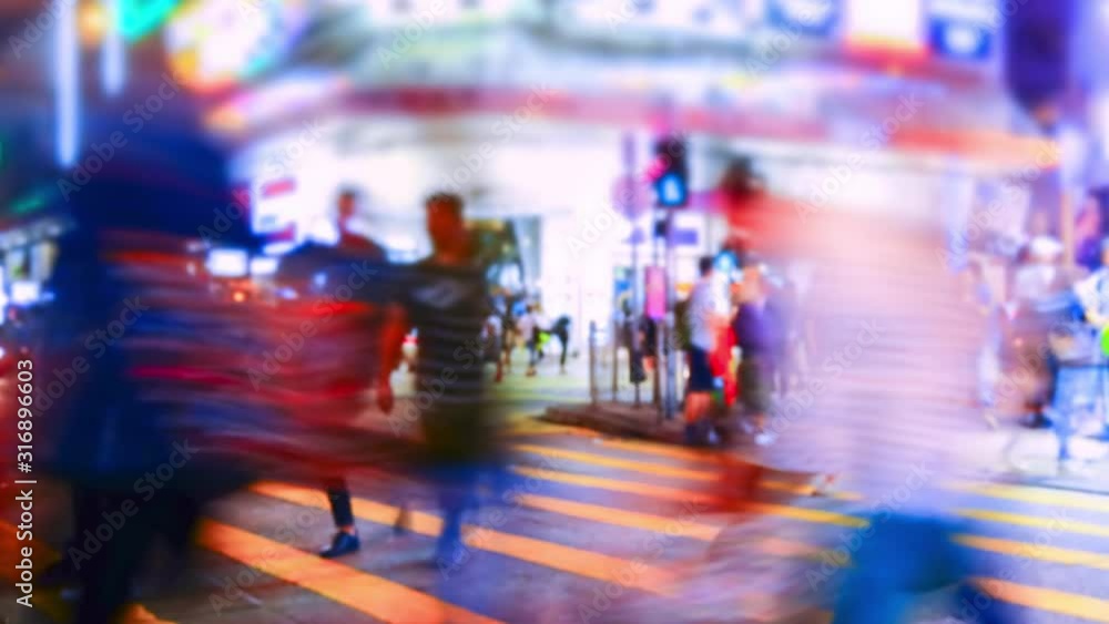 Pedestrians going on crosswalk in Hong Kong in evening. Buildings and skyscrapers illuminated at night. Busy life of asian metropolis with traffic. Tilt shift lens and blur effect. Time lapse Pedestrians going on crosswalk in Hong Kong in evening. Buildings and skyscrapers illuminated at night. Busy life of asian metropolis with traffic. Tilt shift lens and blur effect. Time lapse