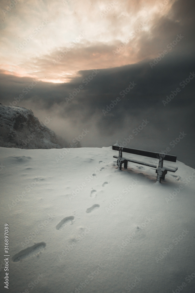bench in the snow on a mountain peak in winter