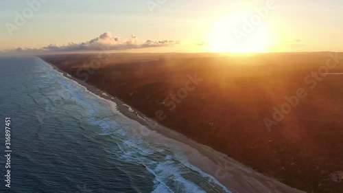 Beautiful high angle aerial drone footage of famous Seventy Five Mile Beach near Dundubara Creek on Fraser Island, Queensland, Australia, shortly before sunset. Mist over the forest. photo