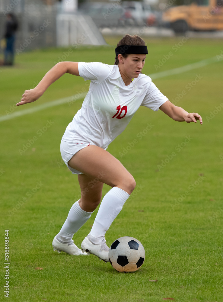 Obraz premium Young athletic girl playing in a soccer match