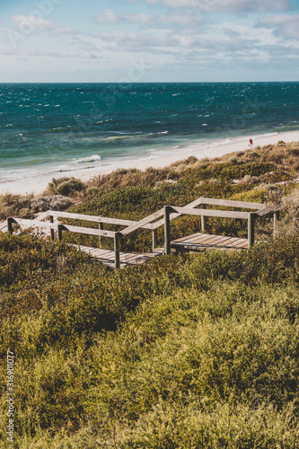 view of Cottesloe beach near Perth with thick vegetations and staircases leading to the sandy shore