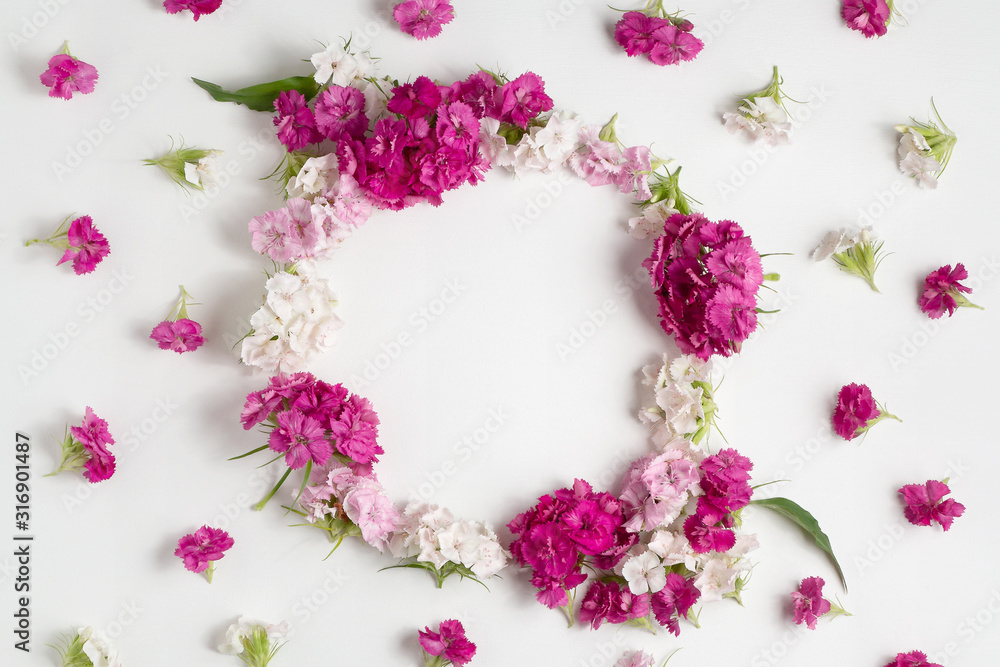 Floral arrangement with copy space. Template for greeting card or design. Frame of pink carnations on a white wooden background Floral arrangement with copy space. Template for greeting card or design. Frame of pink carnations on a white wooden background