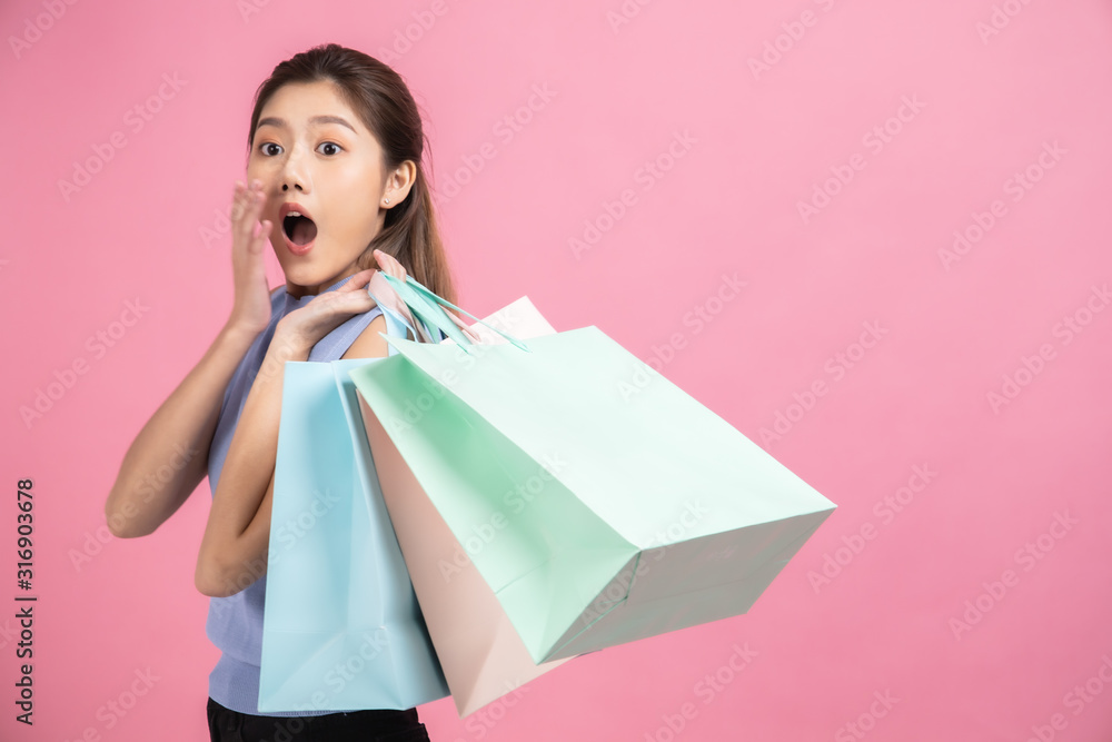 Asian pretty young woman sitting on pink pastel background. She smiling and happy shopping bags. she nice-looking lovely attractive shine She holding mobile. Asian pretty young woman sitting on pink pastel background. She smiling and happy shopping bags. she nice-looking lovely attractive shine She holding mobile.
