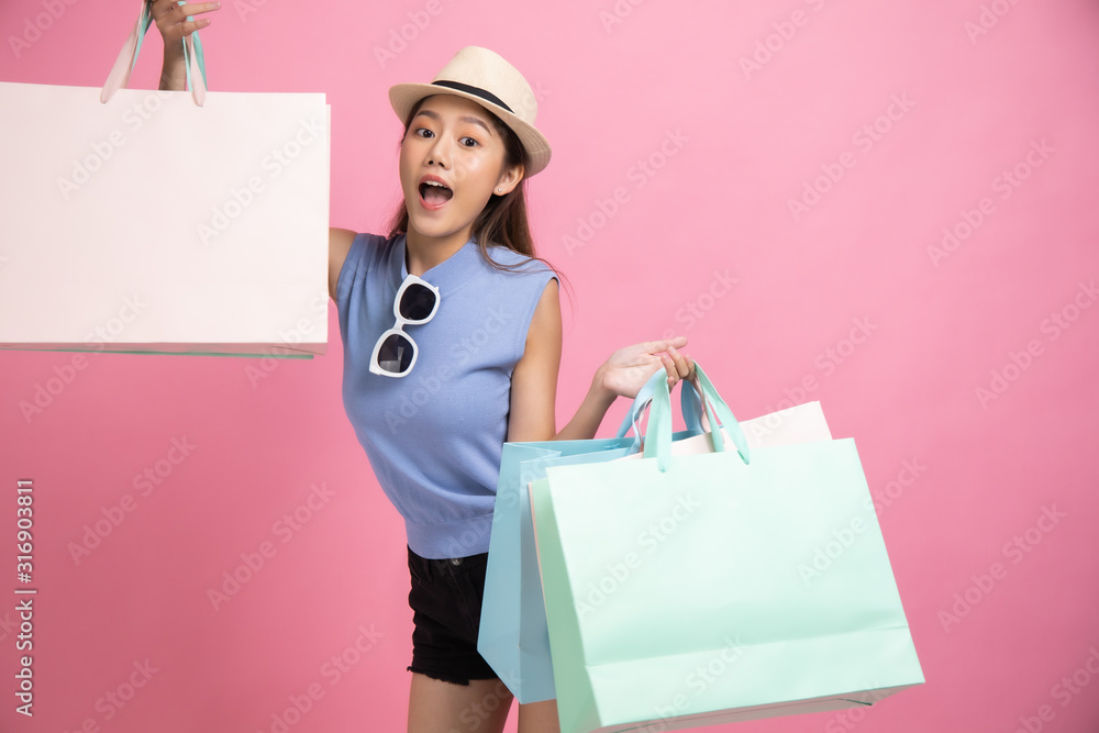 Asian pretty young woman sitting on pink pastel background. She smiling and happy shopping bags. she nice-looking lovely attractive shine She holding mobile. Asian pretty young woman sitting on pink pastel background. She smiling and happy shopping bags. she nice-looking lovely attractive shine She holding mobile.