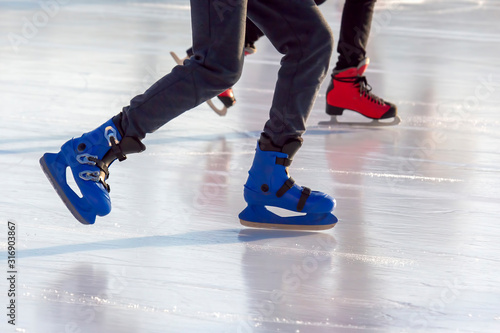 different people are actively skating on an ice rink