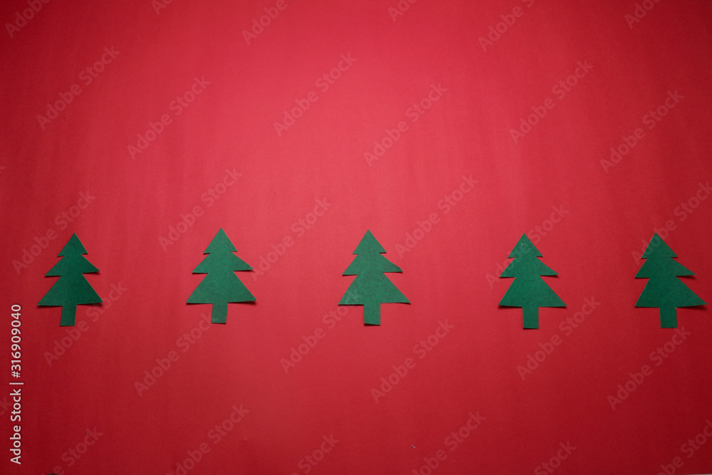 Handmade simple cutting paper craft Christmas tree on red paper ,minimalism concept Handmade simple cutting paper craft Christmas tree on red paper ,minimalism concept