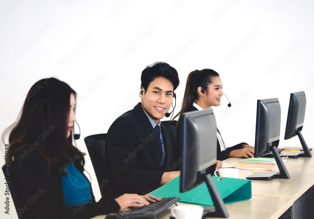Positive smile young business staff asian man using headphone and computer for support. Positive smile young business staff asian man using headphone and computer for support.