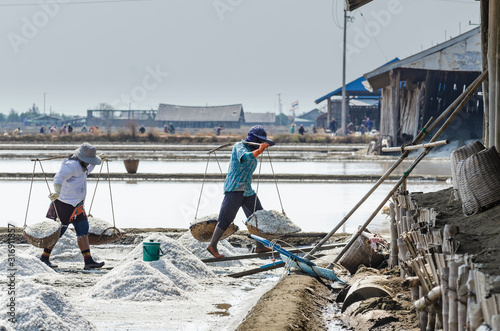 Salters are carrying salts in the salt garden in Ban Laem, Phetchaburi, Thailand. © Loveseen