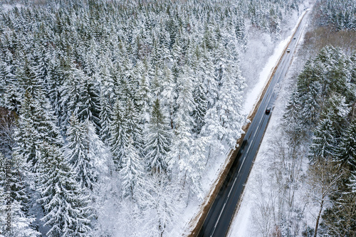 aerial view of the road through a winter forest covered with snow. cars on road in winter scenery © Mr Twister