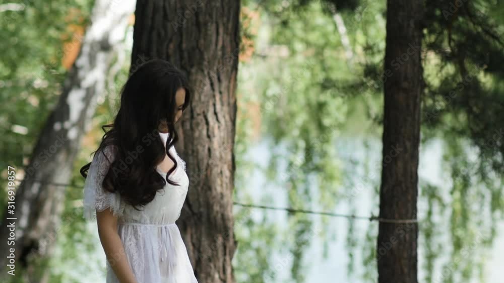 Girl waves curly hair in forest Girl waves curly hair in forest