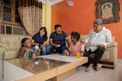 Happy family playing with cards in the living room at home.