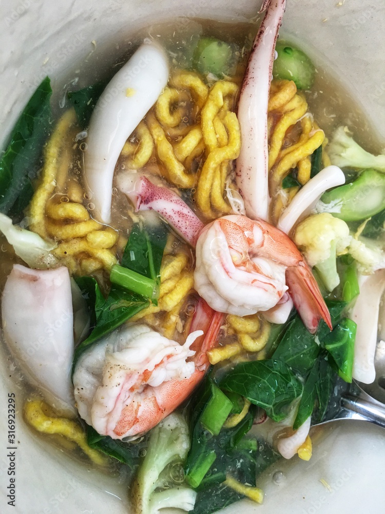 Thai noodles topped with seafood in gravy Thai noodles topped with seafood in gravy
