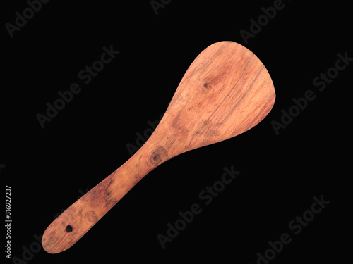 a wooden spatula isolated on black background