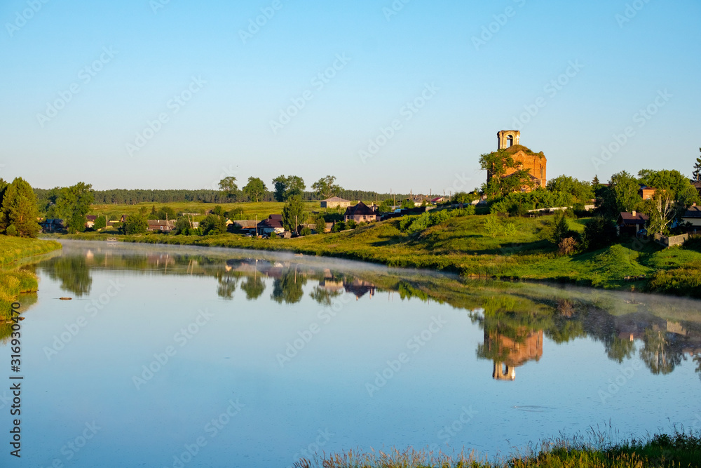 rural landscape of Central Russia river and dilapidated Church on the Bank
