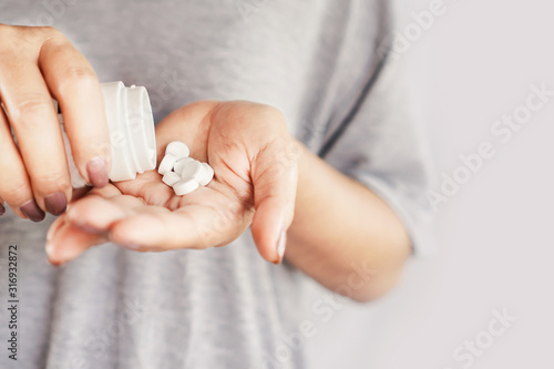 closeup woman hand holding medicine bottle taking overdose pills  photo