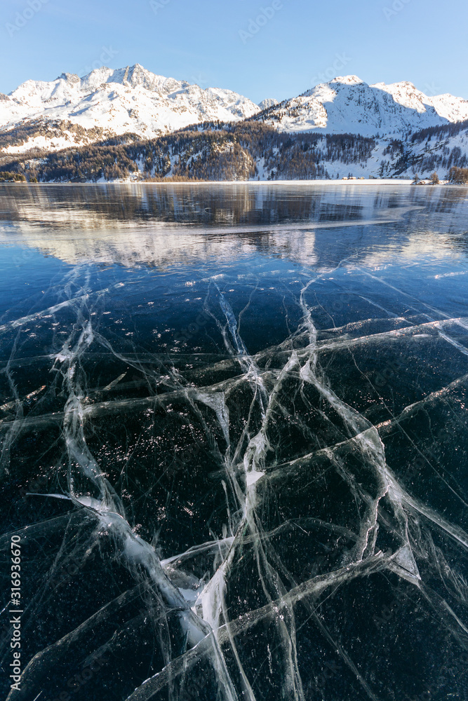 Cracks on the surface of the blue ice on frozen lake in winter ...