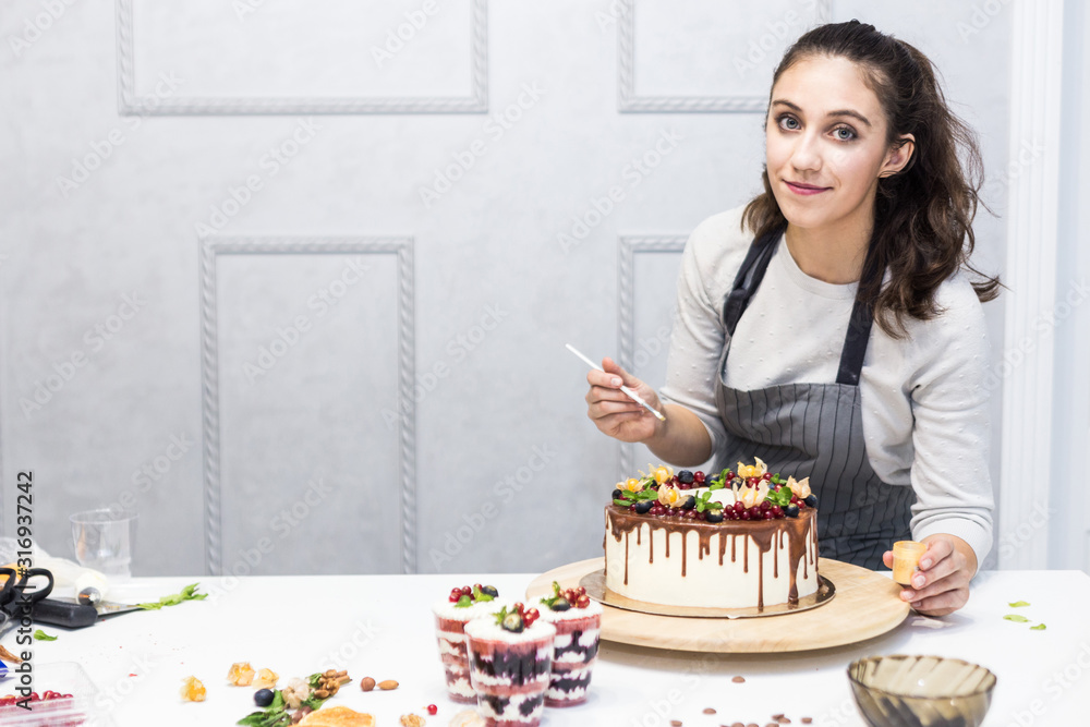 Decoration of the finished dessert. Pastry chef sprinkles confectionery with yellow powder. The concept of homemade pastry, cooking cakes. Decoration of the finished dessert. Pastry chef sprinkles confectionery with yellow powder. The concept of homemade pastry, cooking cakes.