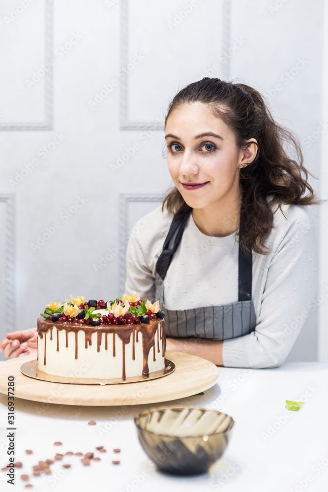 Decoration of the finished dessert. Pastry chef sprinkles confectionery with yellow powder. The concept of homemade pastry, cooking cakes. Decoration of the finished dessert. Pastry chef sprinkles confectionery with yellow powder. The concept of homemade pastry, cooking cakes.