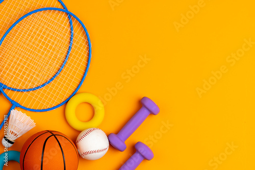 Assortment of sport equipment on yellow background, top view