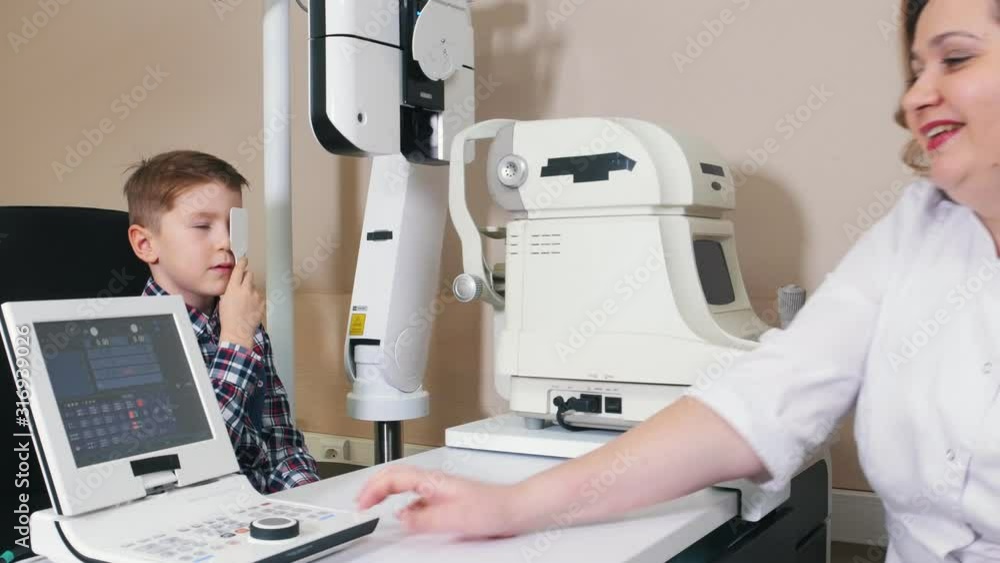 Ophthalmologist treatment - a woman doctor gives a boy an eye shield Ophthalmologist treatment - a woman doctor gives a boy an eye shield