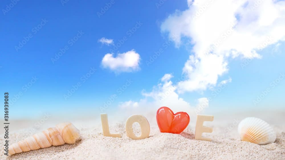 red Heart shape and love wooden text on white sand beach with tropical blue sea and cloudy blue sky red Heart shape and love wooden text on white sand beach with tropical blue sea and cloudy blue sky
