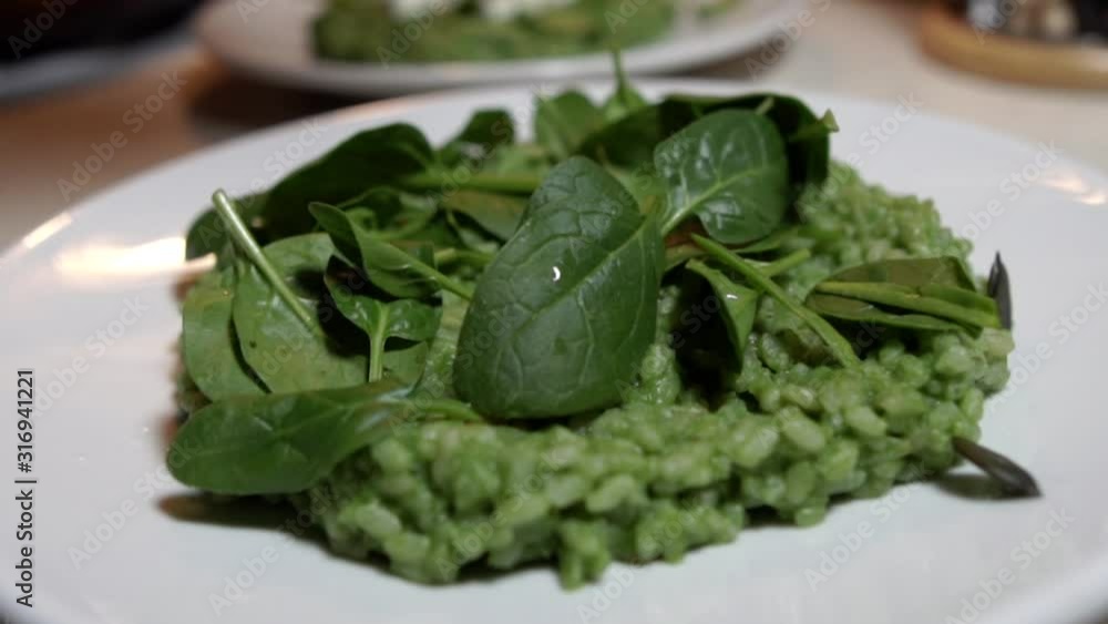 Garnishing green spinach risotto with dried pumpkin seeds, SLOW MOTION Garnishing green spinach risotto with dried pumpkin seeds, SLOW MOTION